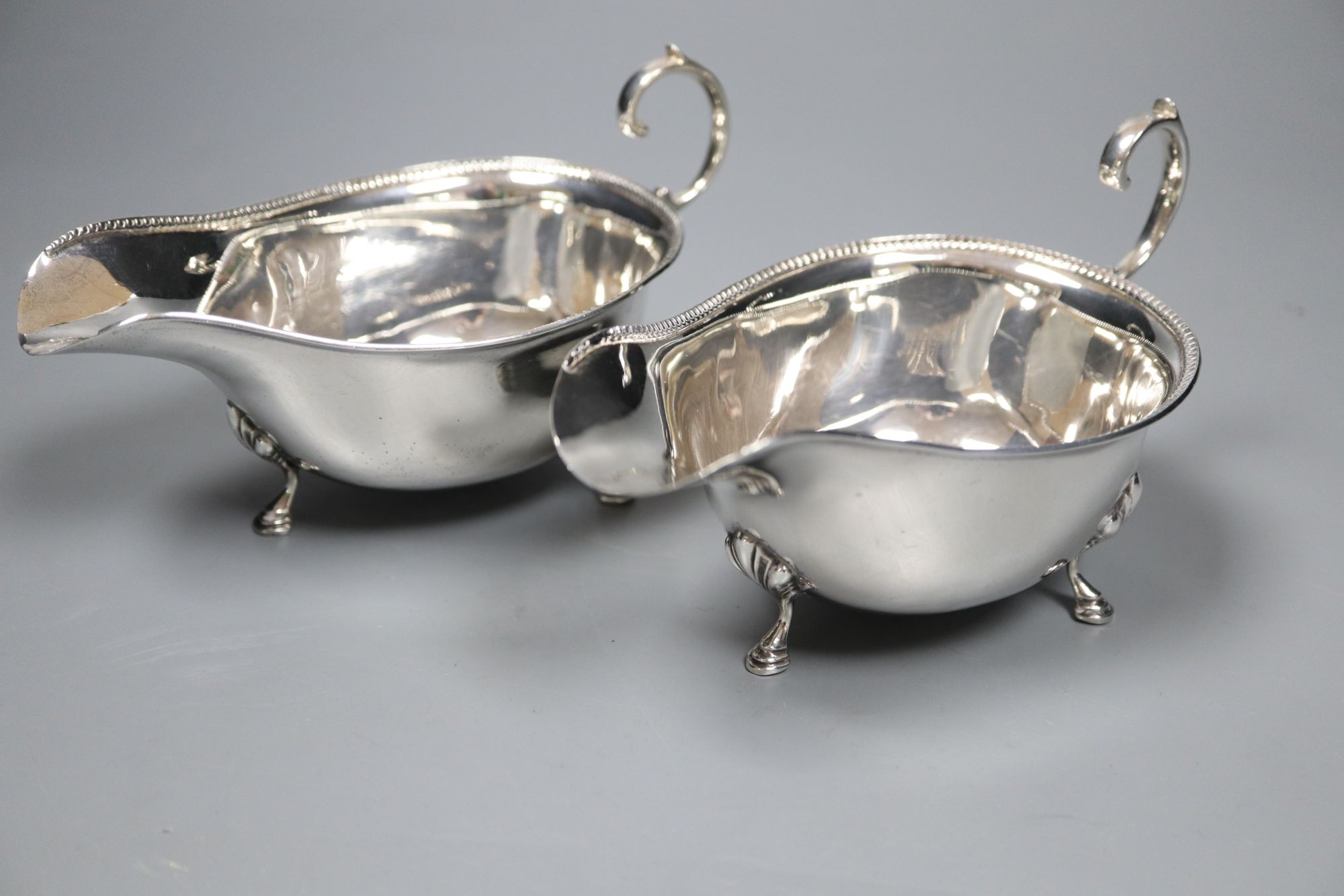 A pair of 1930s silver sauceboats, 5.5 oz and a plated sauceboat.